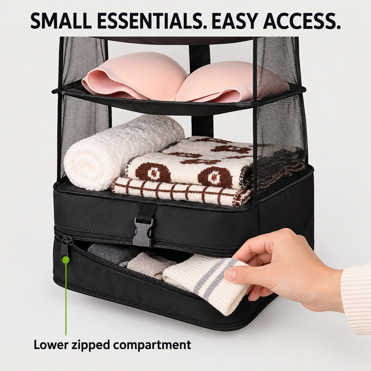 Hand retrieving folded socks from the lower zipped compartment of the black hanging organizer.
